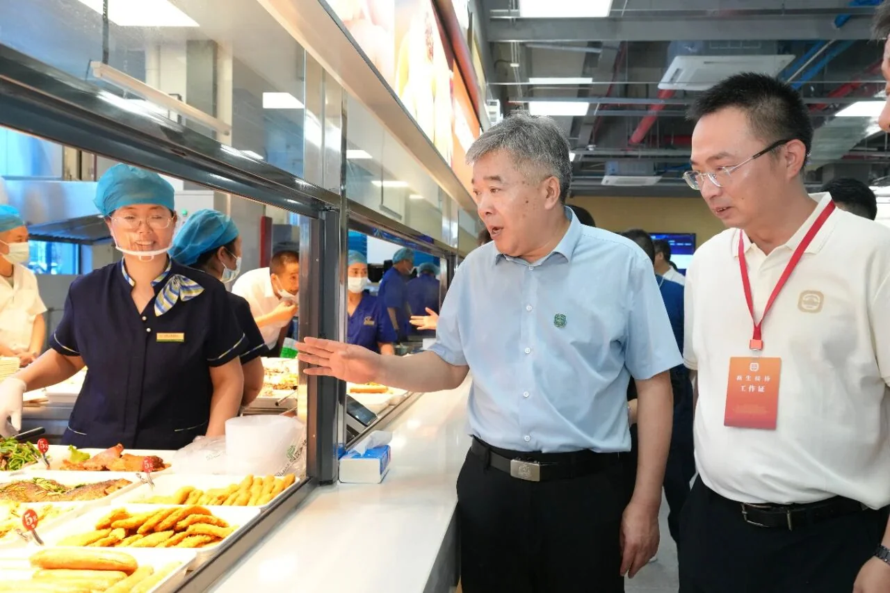 南京师范大学海棠苑新食堂取餐窗口，工作人员在窗口内备餐
